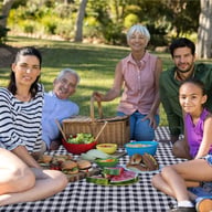 Family enjoying outdoor meal on foldable waterproof ground pad in backyard
