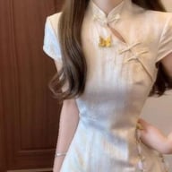 Close-up of cream cheongsam dress with mandarin collar and frog closures detail