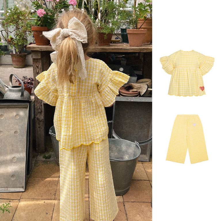 Close-up of yellow plaid fabric texture and heart patch detail on kids' clothing