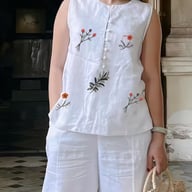 White linen two-piece set with floral embroidery, relaxed fit sleeveless top and wide-leg pants
