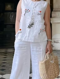 Woman wearing white linen set with embroidered floral details, comfortable relaxed styling
