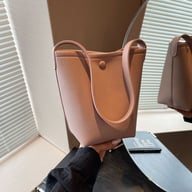 Brown pebbled leather tote bucket bag with shoulder strap detail