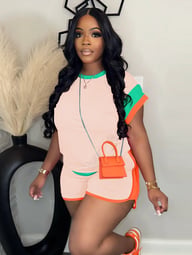 Woman in vibrant green and orange two-piece casual outfit with contrasting sleeve trim