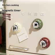 Three colorful magnetic kitchen timers attached to SMEG refrigerator