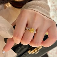 Yellow diamond sugar cube ring on hand with floral background detail