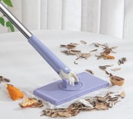Mini mop cleaning debris on white table with compact flat head