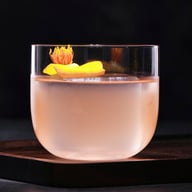 Crystal whisky glass filled with amber drink and flower garnish on serving tray