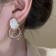 Close-up of sparkly zircon geometric loop earring worn on ear, gold-tone plating detail