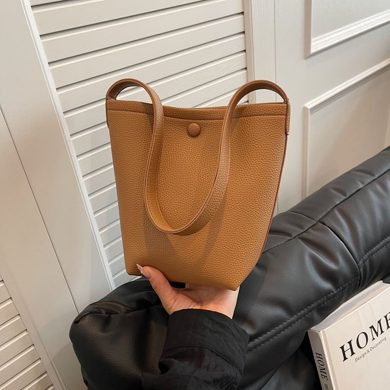 Purple pebbled leather bucket bag displayed on neutral surface