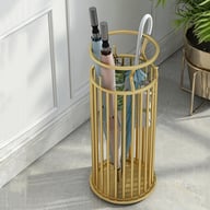 Gold wrought iron umbrella stand with umbrellas displayed near home entrance door