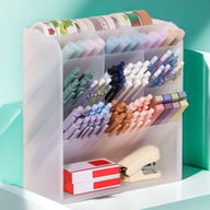 Transparent cosmetic organizer with pens, washi tape, and office supplies organized by type