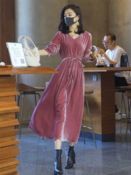 Woman in pink velvet dress walking, showing comfortable loose-fitting silhouette and tie waist