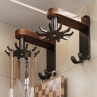 Walnut wood swivel kitchen hooks mounted on tiled wall with utensils