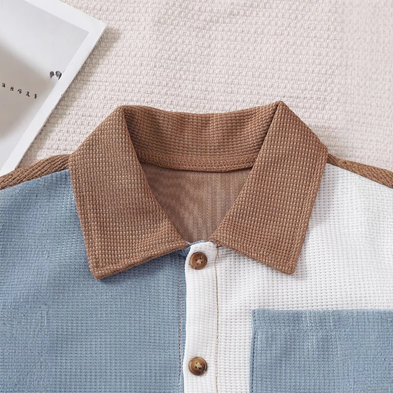 Close-up of boy's shirt collar, buttons, and color-blocked design details