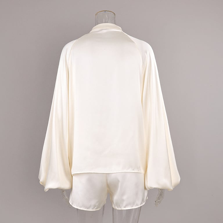 Styled off-white satin pajama set displayed on white background