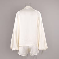 Close-up detail of lace trim and tie-front closure on satin pajama top