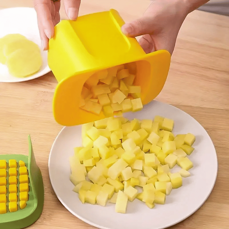 Diced potatoes being emptied from chopper onto white plate, ready to cook