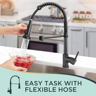 Matt black kitchen tap with pull-out hose spraying fresh red tomatoes