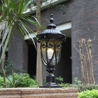 European-style outdoor column lamp illuminates brick pillar in garden courtyard