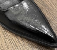 Close-up of pointed toe detail on black Mary Jane shoe with buckle strap