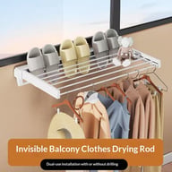 White wall-mounted folding clothes drying rack with garments hung for drying