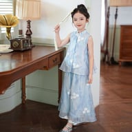 Young girl in blue floral vest top and wide-leg pants near wooden desk