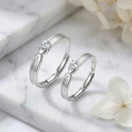 Matching sterling silver couple rings with cubic zirconia on marble surface