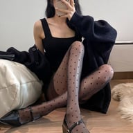 Woman wearing black vintage Mary Jane shoes with pointed toe and polka dot tights
