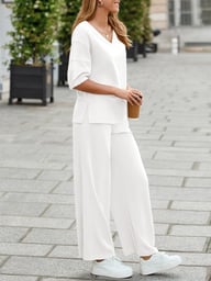 Woman in white tracksuit set holding coffee, side view casual wear