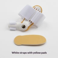 White bunion corrector with yellow padding and adjustable Velcro straps for toe alignment