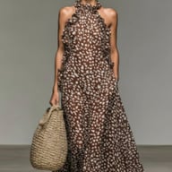 Model wearing brown speckled maxi dress with ruffled halter neckline and pockets