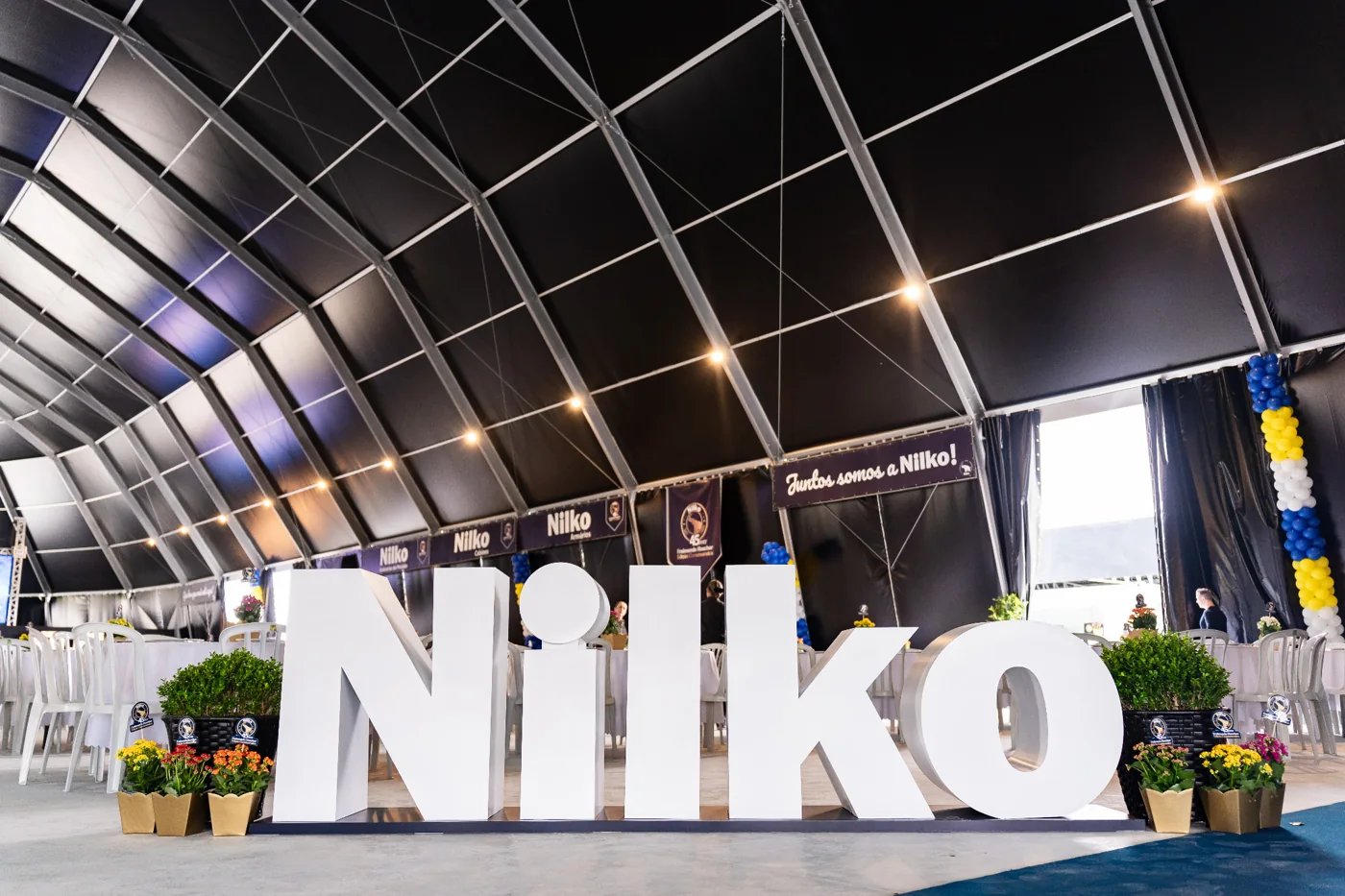 Letras brancas formando Nilko e decoração do evento de 45 anos, em 2025