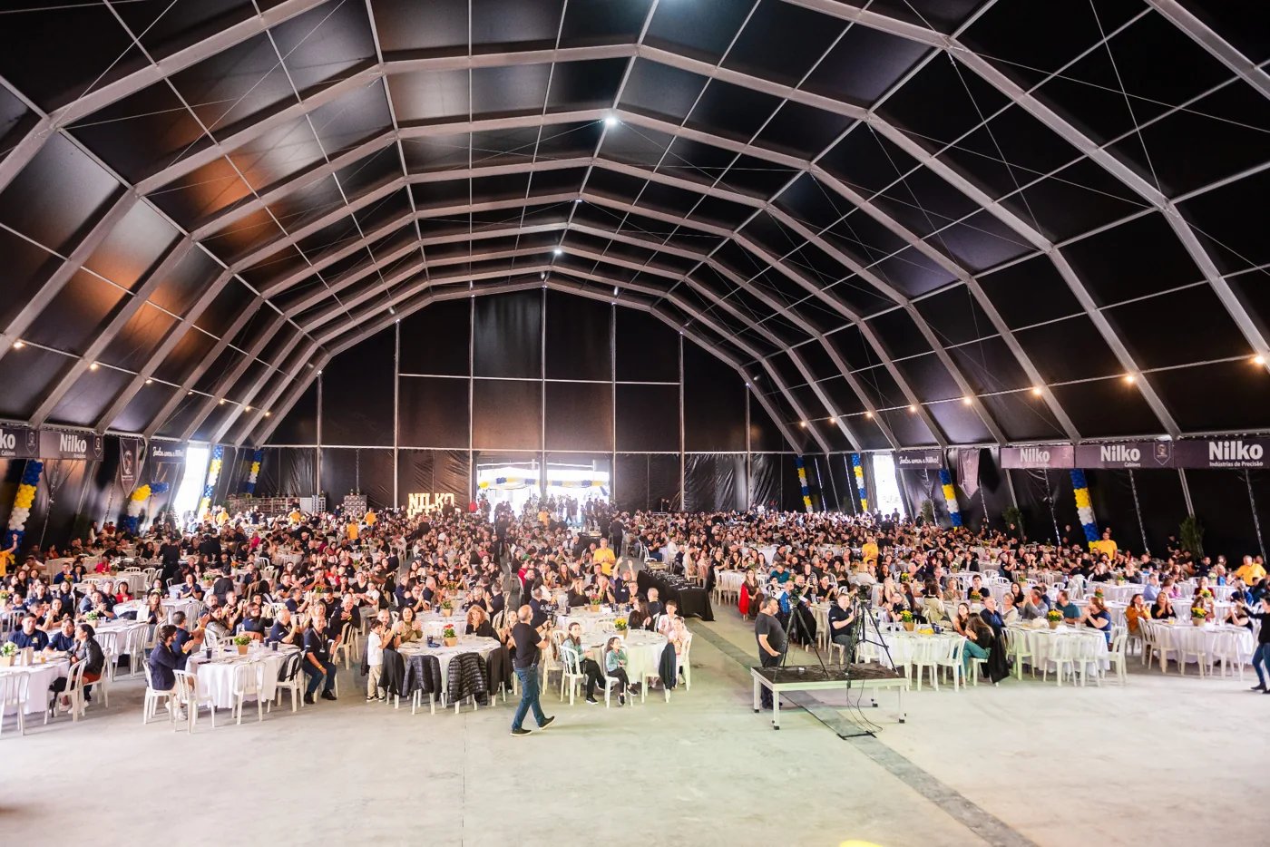 Público reunido em mesas no evento de comemoração dos 45 anos da Nilko, em 2025
