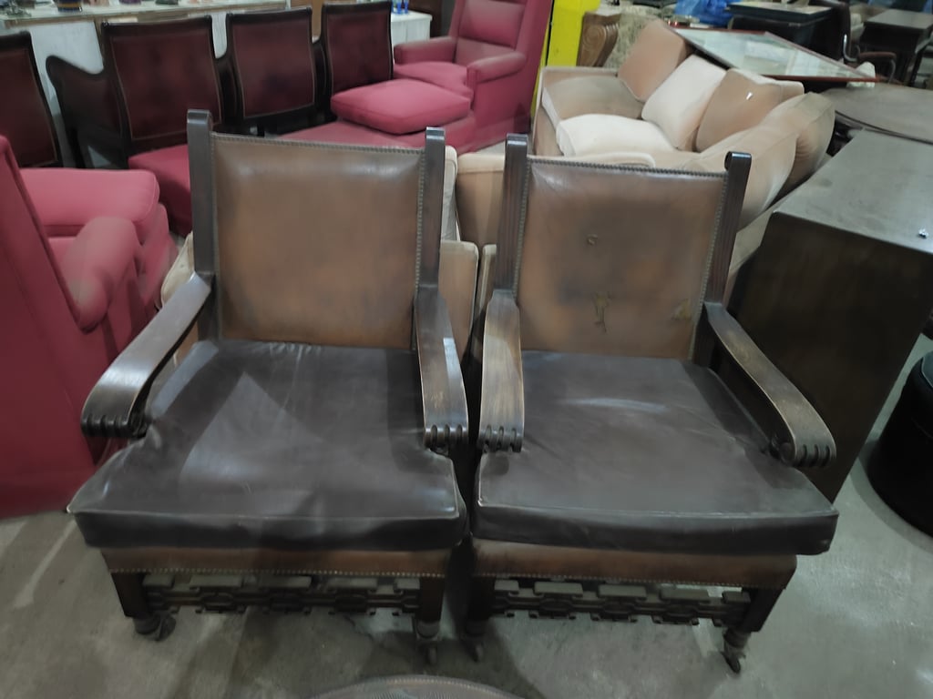 Sillones  con rueditas, de madera con almohadones y respaldero con tapizado de cuero