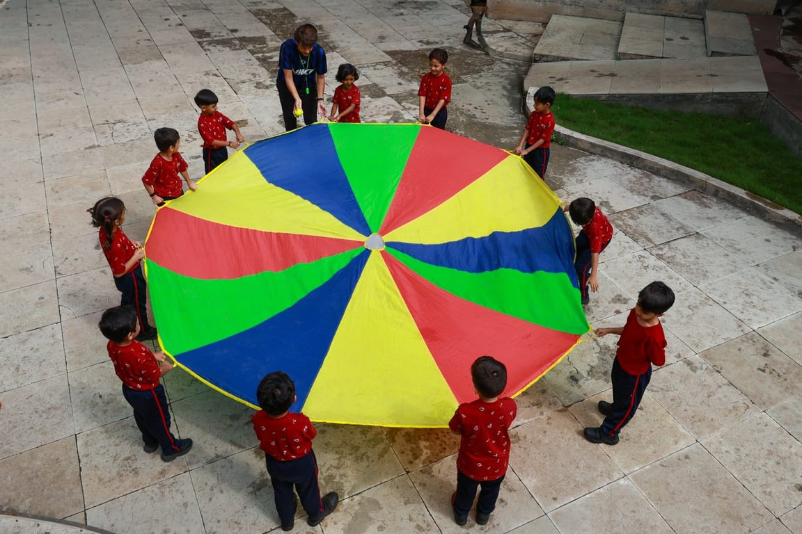 Early years parachute play in the courtyard