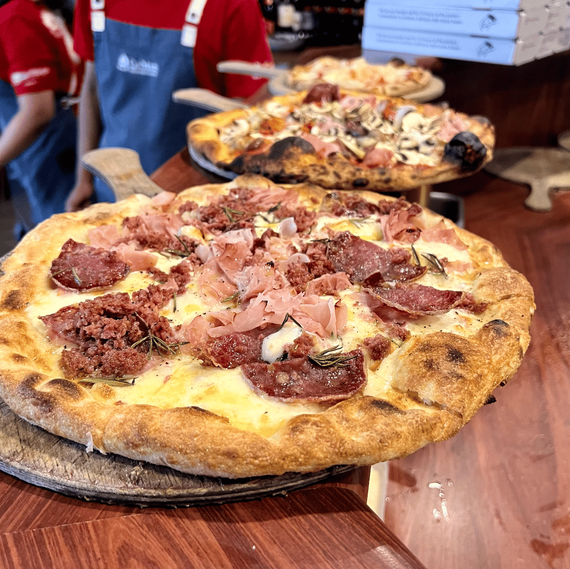 A pizza with salami, prosciutto and rosemary