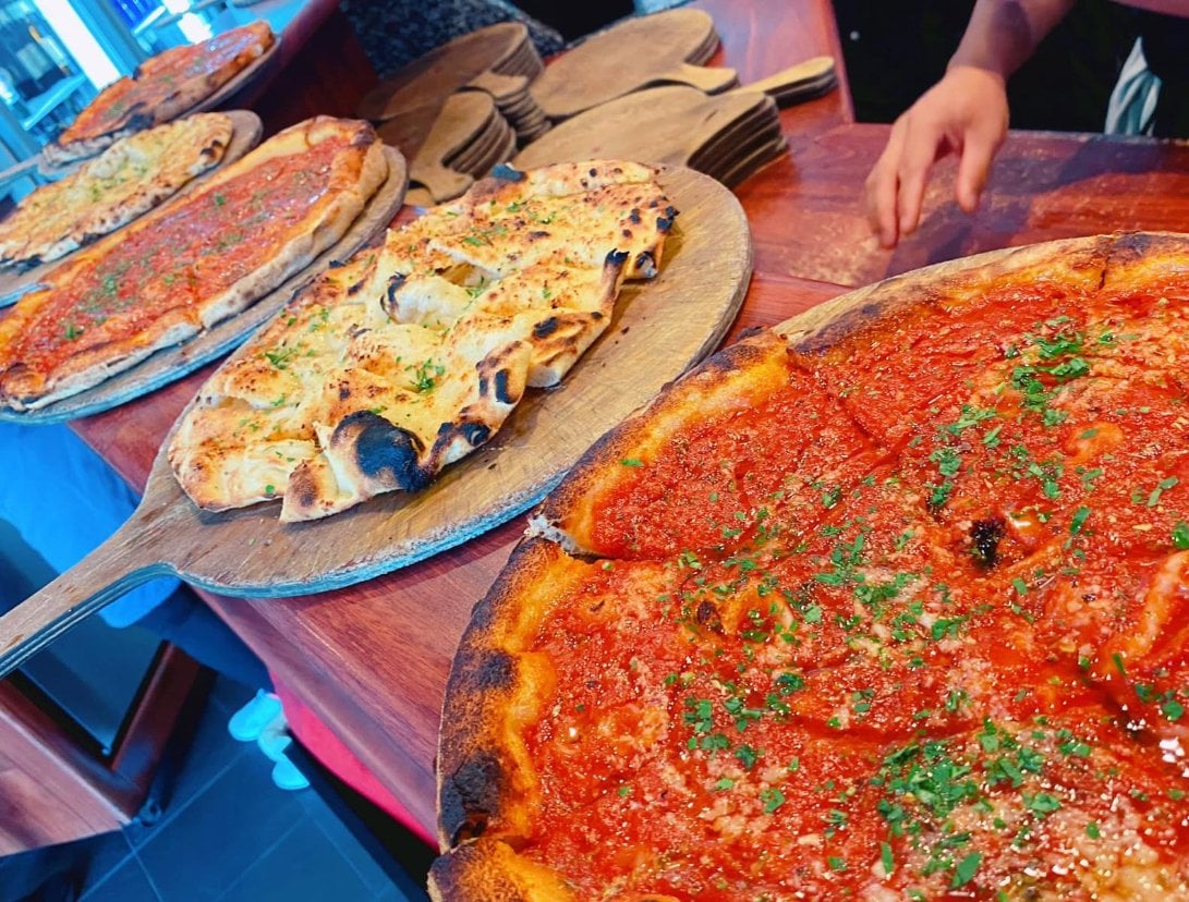 Pizzas on boards on the counter