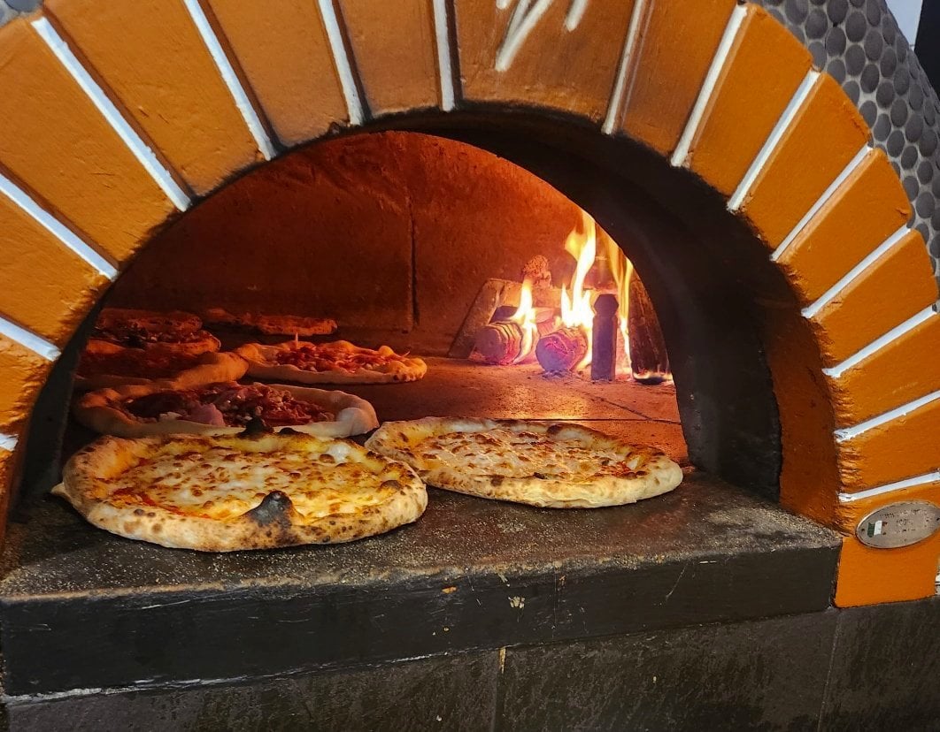 Pizzas cooking in the tiled oven