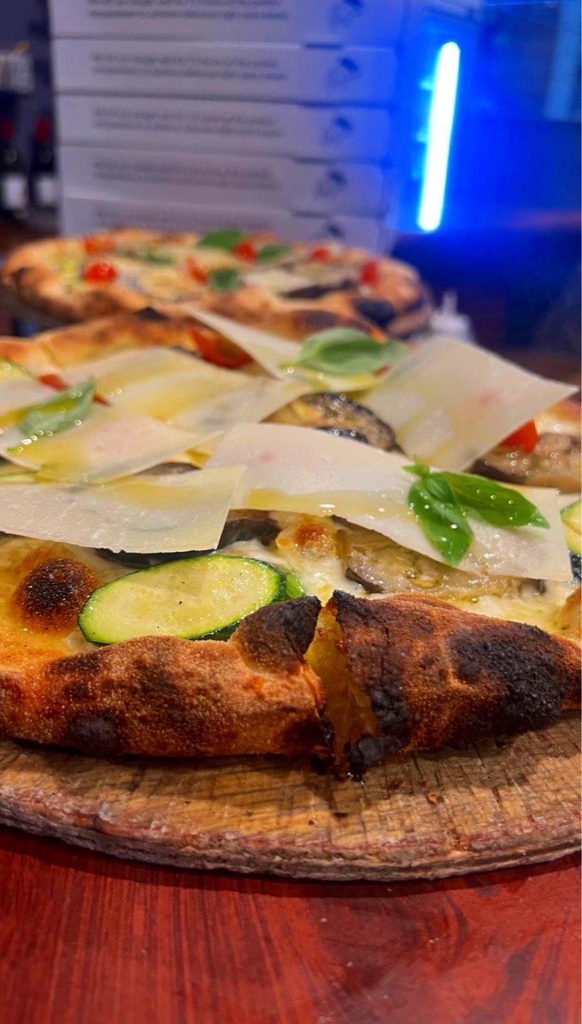A pizza with zucchini, eggplant and shaved parmesan