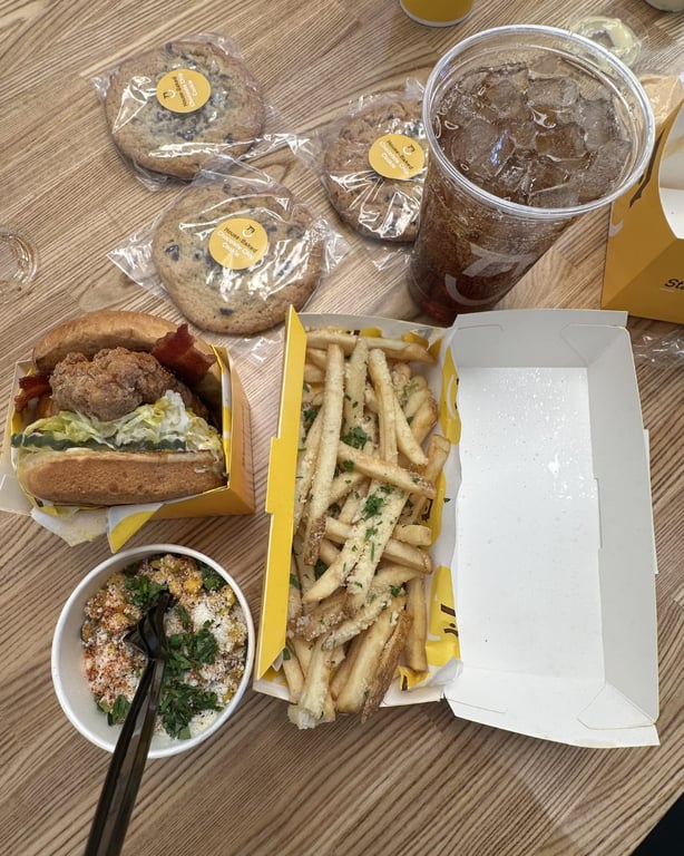 Starbird Chicken food including Cali Gold BBQ Bacon Sandwich, truffle fries, elote corn, cookies, and Alameda Point soda