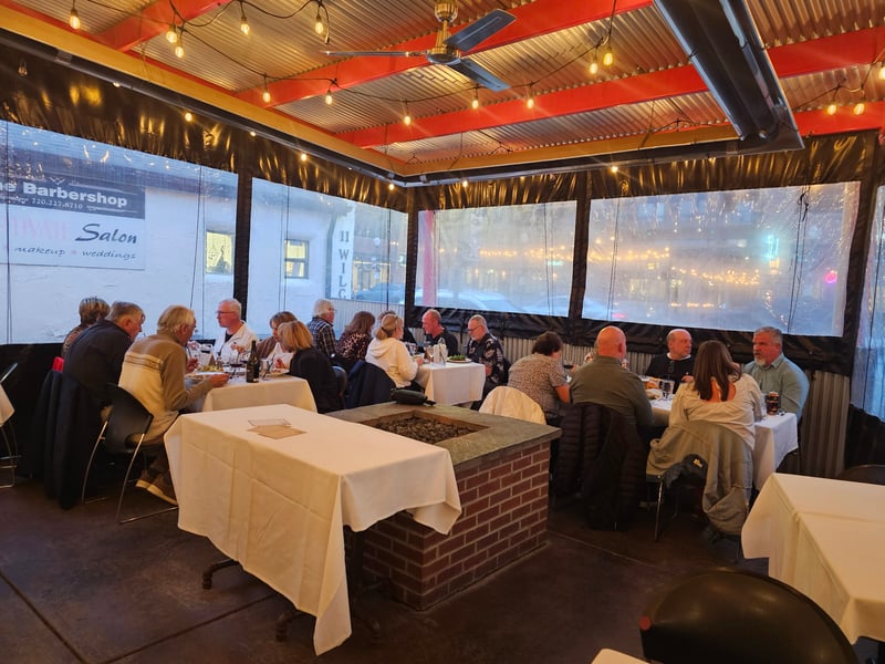 Wide view of the Couples Dinner venue with string lights and dining tables