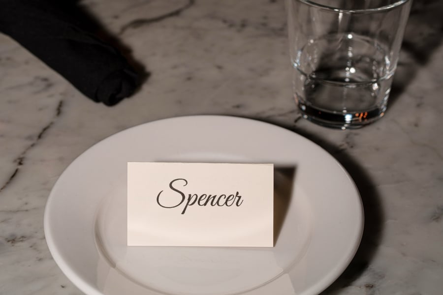 A place setting at a DougCo Social Dinner Club table with a handwritten name card