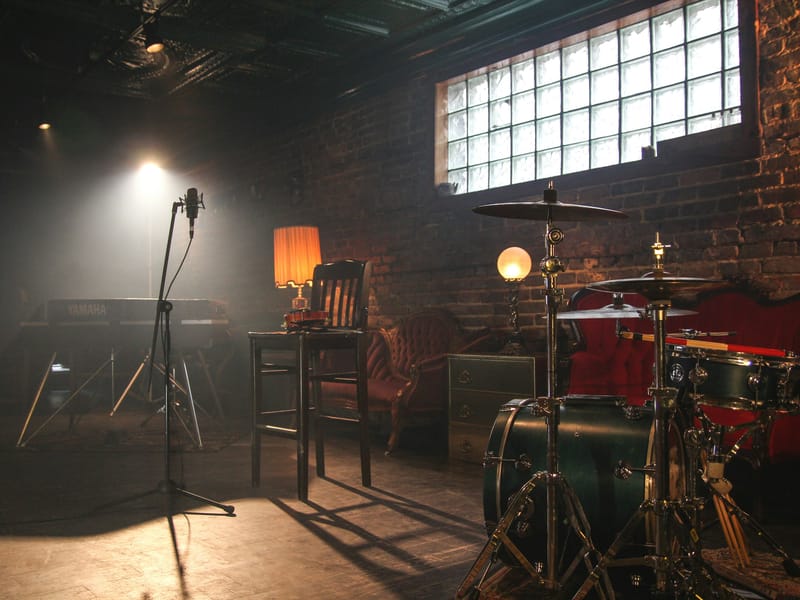 Illustrative image: a dimly lit music room with a drum kit and stage lights