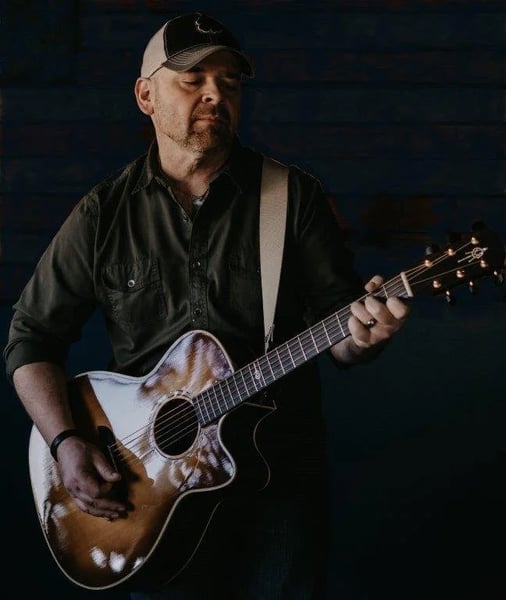 Musician Byron Miller playing acoustic guitar, promo photo for his show at The Old North End