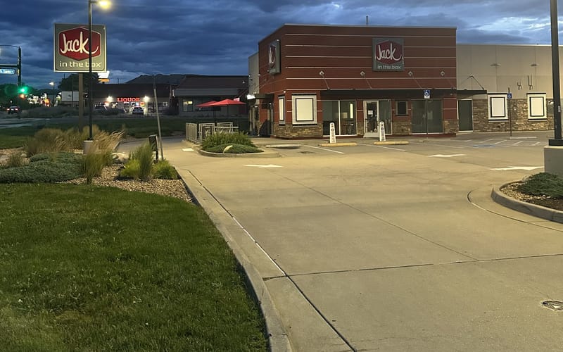 The closed Jack in the Box at 27 E Wolfensberger Rd in Castle Rock at dusk, windows papered over with the signs still up