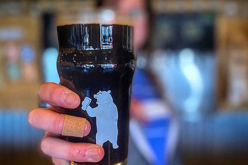 A pint of dark beer in a 105 West Brewing bear glass