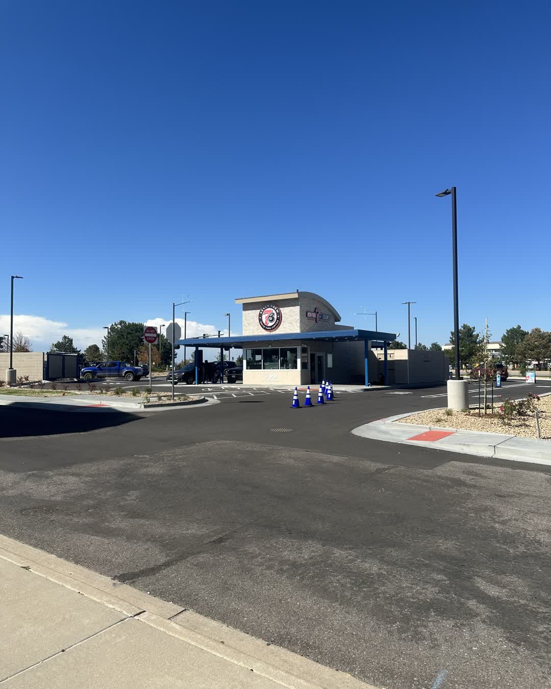 7 Brew Coffee's drive-thru building open for business at Castle Pines Parkway and Debbie Lane, with a car at the window and traffic cones still out front