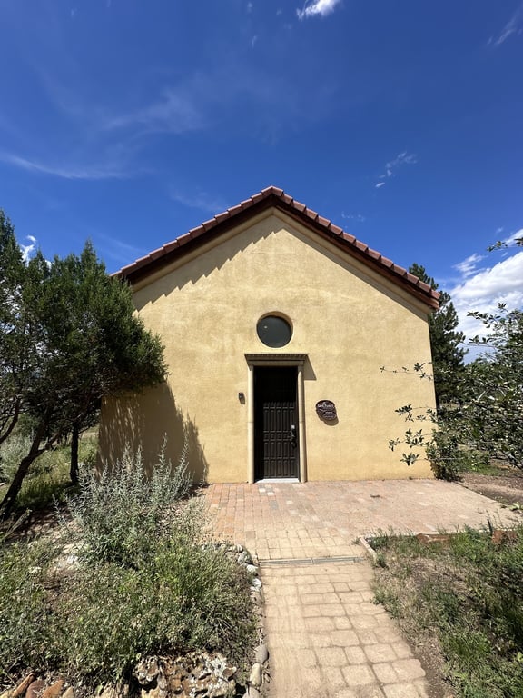 The adobe chapel at A Sanctuary Center with its red tile roof and round window