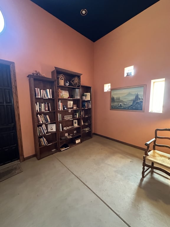 Inside the chapel at A Sanctuary Center — a vaulted navy ceiling, terracotta walls and the lending library shelves