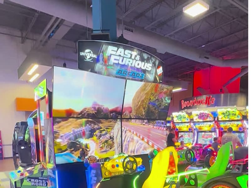 The Fast & Furious arcade racers and neon game cabinets inside Boondocks Food & Fun in Parker